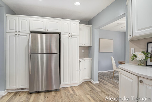 1046 Kenesaw Dr SE, East Grand Rapids, MI 49506 - kitchen with freestanding refrigerator, white cabinets, decorative backsplash, light wood-type flooring, and recessed lighting