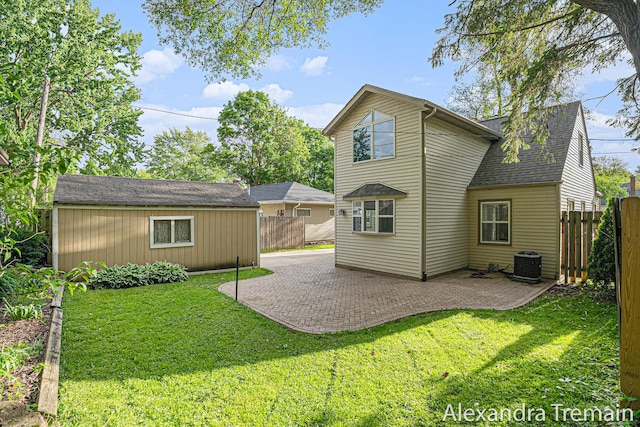 1046 Kenesaw Dr SE, East Grand Rapids, MI 49506 - rear view of house featuring cooling unit, an outbuilding, a patio, and a shingled roof