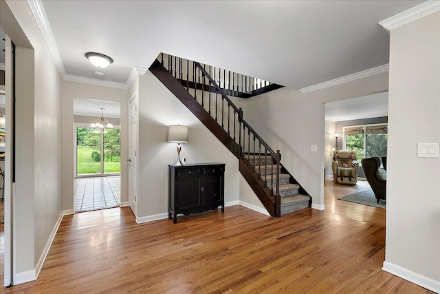 4047 Ramsgate Ct, Ann Arbor, MI 48103 - entryway with stairs, wood finished floors, baseboards, crown molding, and a chandelier
