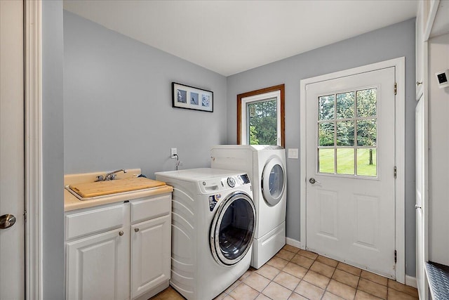 4047 Ramsgate Ct, Ann Arbor, MI 48103 - laundry room with washing machine and dryer, cabinet space, light tile patterned flooring, and baseboards