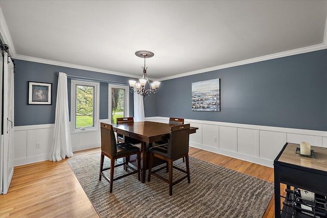 4047 Ramsgate Ct, Ann Arbor, MI 48103 - dining room with a chandelier, ornamental molding, light wood-style flooring, a wainscoted wall, and a decorative wall