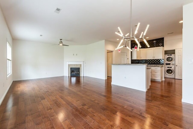 1732 Peachtree Path Unit 4, Stevensville, MI 49127 - unfurnished living room featuring estacked washer and dryer, dark wood finished floors, a glass covered fireplace, ceiling fan, and recessed lighting