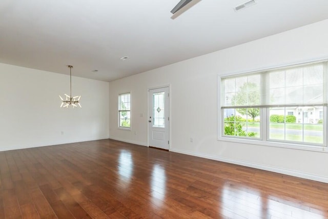 1732 Peachtree Path Unit 4, Stevensville, MI 49127 - empty room with a chandelier, dark wood-style flooring, and baseboards