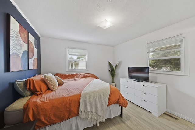 2837 Elmwood Dr, Adrian, MI 49221 - bedroom featuring light wood-style flooring, multiple windows, and baseboards