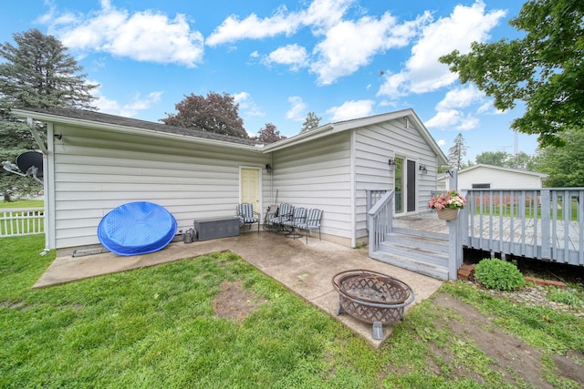 2837 Elmwood Dr, Adrian, MI 49221 - back of property featuring a fire pit, a deck, a patio area, and a lawn