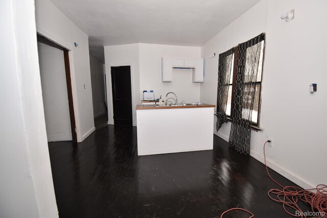 2688 Montgomery St, Detroit, MI 48206 - kitchen featuring dark wood-style flooring, baseboards, a sink, white cabinetry, and wood counters