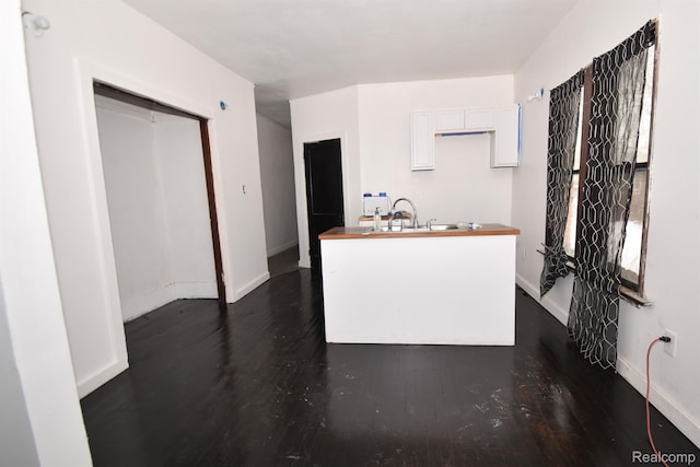 2688 Montgomery St, Detroit, MI 48206 - kitchen with baseboards, dark wood-style flooring, white cabinetry, and an island with sink