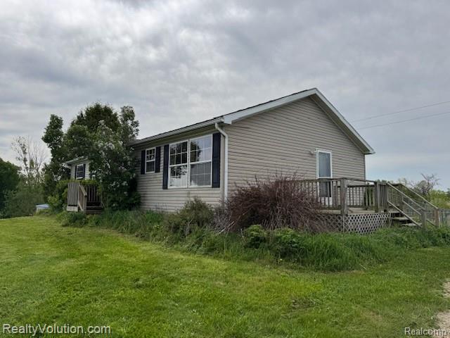 5736 Burnside Rd, North Branch, MI 48461 - view of side of property with a wooden deck and a lawn