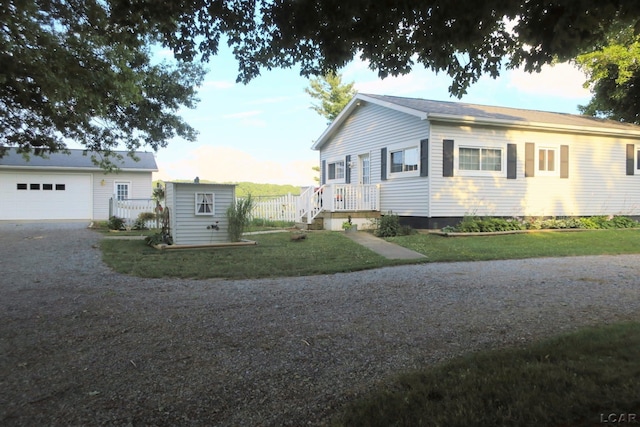 12765 Sand Creek Highway, Sand Creek, MI 49279 - view of property exterior with an outbuilding, gravel driveway, a garage, and a yard