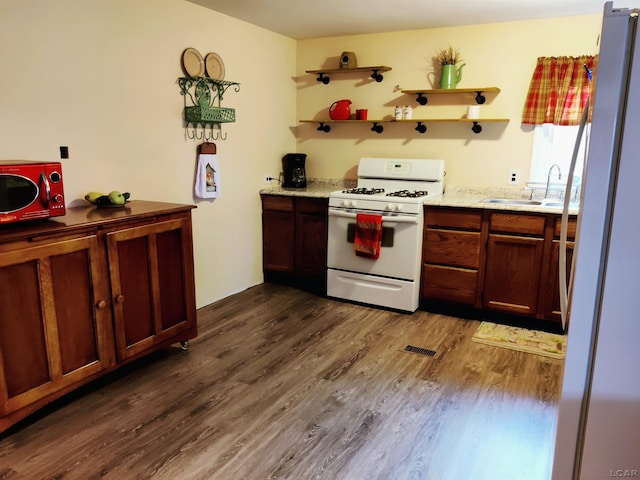 12765 Sand Creek Highway, Sand Creek, MI 49279 - kitchen featuring white appliances, a sink, dark wood-style flooring, open shelves, and light stone counters