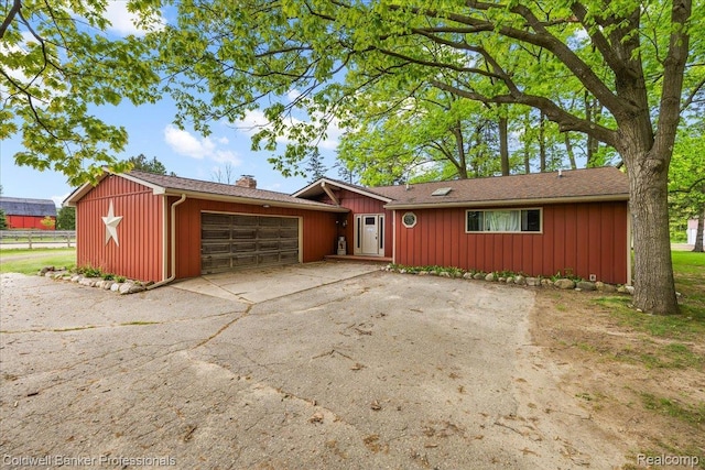 5240 Thomas Rd, Metamora, MI 48455 - ranch-style house with an attached garage, a chimney, board and batten siding, and asphalt driveway