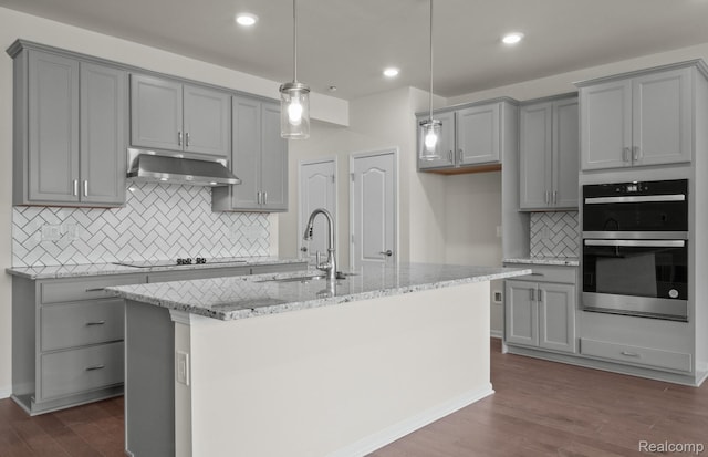4060 Nottingham Cir, Clarkston, MI 48346 - kitchen with gray cabinetry, a sink, under cabinet range hood, double oven, and recessed lighting