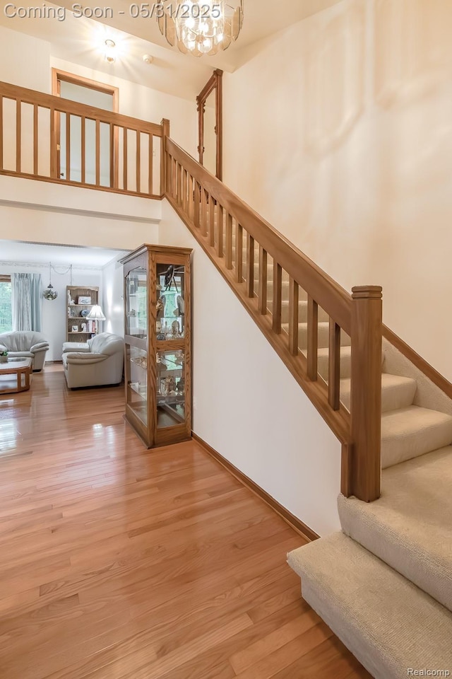 8210 Pine Ridge Dr, Clarkston, MI 48346 - staircase featuring wood finished floors, a chandelier, and baseboards