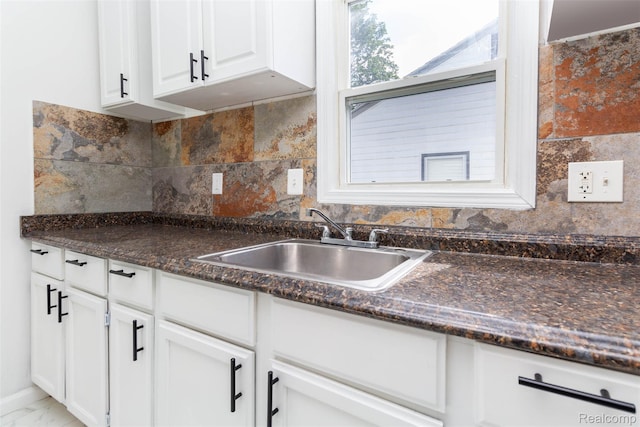 8713 Hupp Ave, Warren, MI 48089 - kitchen with a sink, white cabinetry, backsplash, and dark stone countertops
