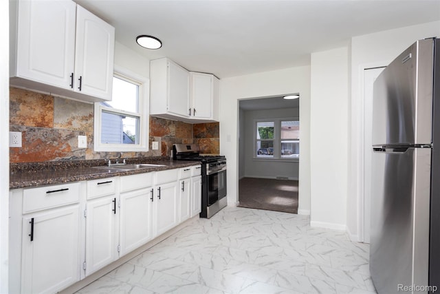 8713 Hupp Ave, Warren, MI 48089 - kitchen featuring stainless steel appliances, a sink, white cabinetry, light marble finish floors, and dark stone counters