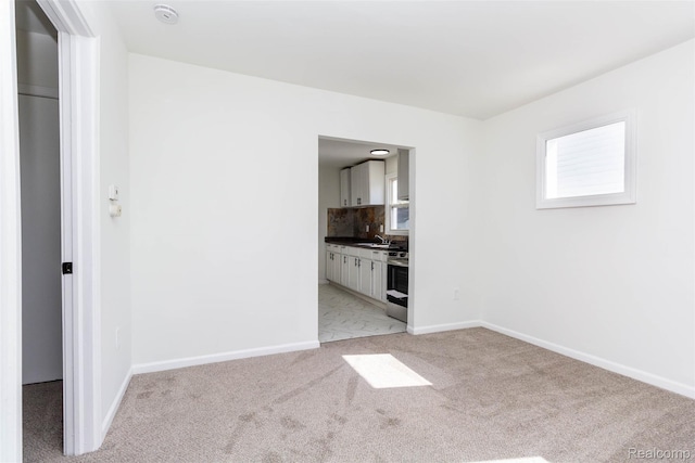 8713 Hupp Ave, Warren, MI 48089 - unfurnished room featuring light colored carpet, a sink, plenty of natural light, and baseboards