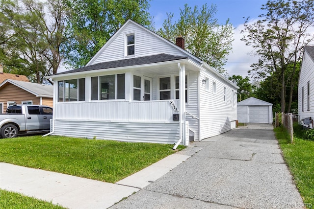 8713 Hupp Ave, Warren, MI 48089 - view of front of home featuring a detached garage, an outdoor structure, a front lawn, a chimney, and driveway