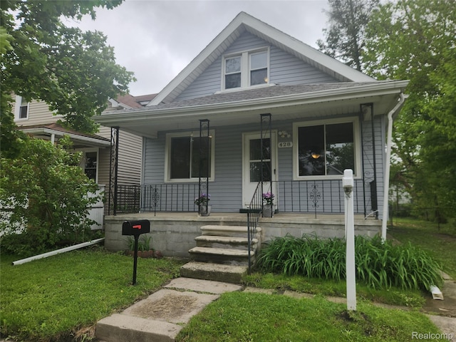 428 E Milton Ave, Hazel Park, MI 48030 - bungalow-style house with a porch, roof with shingles, and a front lawn
