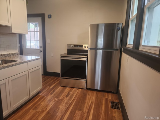 428 E Milton Ave, Hazel Park, MI 48030 - kitchen featuring appliances with stainless steel finishes, dark wood finished floors, white cabinets, and tasteful backsplash