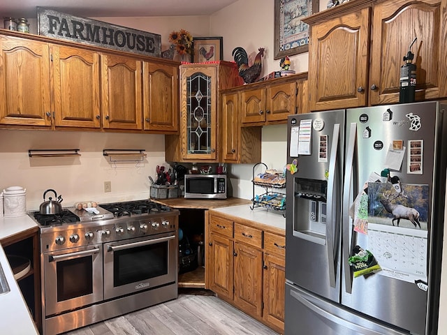 132 W Lansing Rd, Morrice, MI 48857 - kitchen featuring stainless steel appliances, light countertops, brown cabinets, and light wood finished floors
