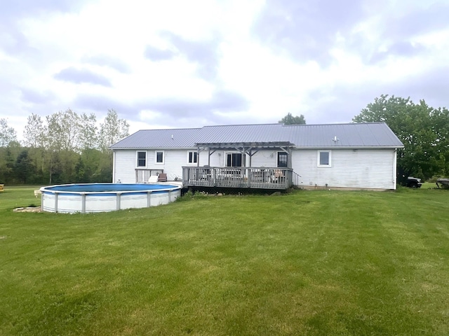 132 W Lansing Rd, Morrice, MI 48857 - back of house featuring a deck, a pergola, an outdoor pool, and a yard
