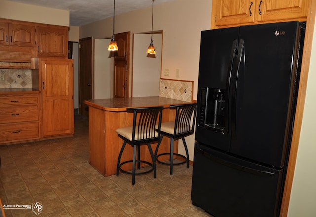 3478 N Gale Rd, Davison, MI 48423 - kitchen featuring black fridge, a peninsula, dark countertops, backsplash, and a kitchen bar