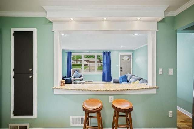 514 Granada Ave, Saint Joseph, MI 49085 - kitchen featuring crown molding, wood finished floors, baseboards, a breakfast bar, and recessed lighting