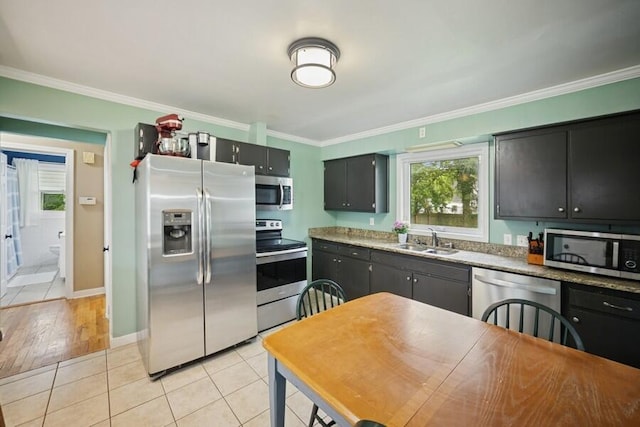 514 Granada Ave, Saint Joseph, MI 49085 - kitchen featuring appliances with stainless steel finishes, a sink, crown molding, light tile patterned floors, and plenty of natural light