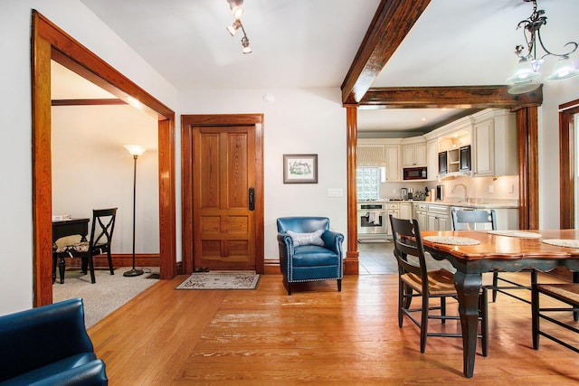 110 N O Keefe St, Cassopolis, MI 49031 - dining space featuring beamed ceiling, light wood-style flooring, and baseboards