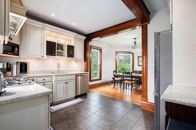 110 N O Keefe St, Cassopolis, MI 49031 - kitchen featuring appliances with stainless steel finishes, a chandelier, a sink, light stone countertops, and dark tile patterned floors