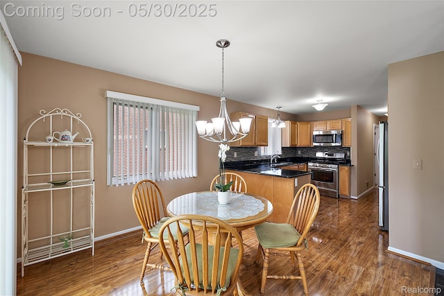 16106 Nathan Dr, Macomb, MI 48044 - dining room featuring baseboards, dark wood-style flooring, and a chandelier
