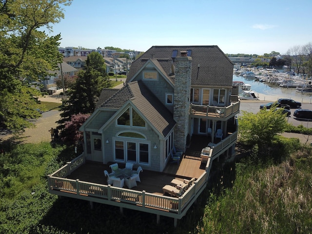 210 E Water St, New Buffalo, MI 49117 - rear view of house with a balcony, a deck with water view, and a chimney