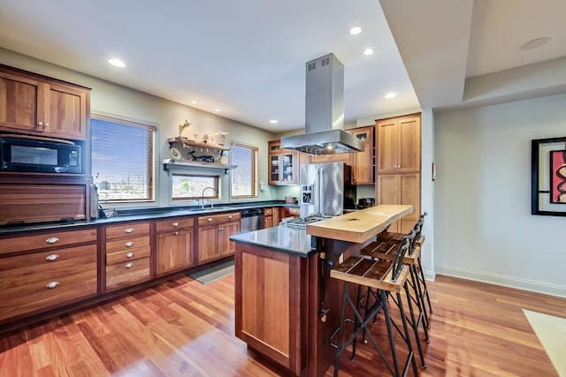 210 E Water St, New Buffalo, MI 49117 - kitchen with island range hood, stainless steel appliances, a kitchen bar, light wood-style flooring, and recessed lighting
