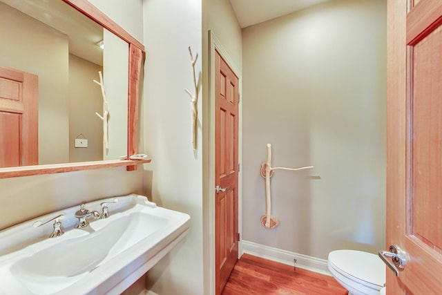 210 E Water St, New Buffalo, MI 49117 - bathroom featuring a sink, wood finished floors, toilet, and baseboards