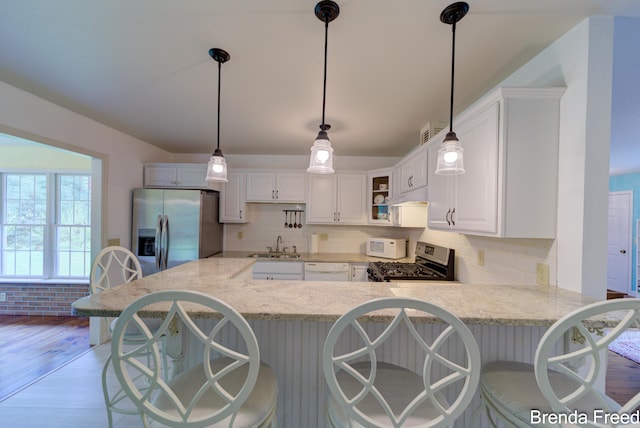7561 Wiczer Dr, Whitehall, MI 49461 - kitchen with appliances with stainless steel finishes, a sink, light wood-style flooring, backsplash, and white cabinets