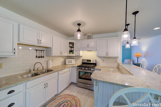 7561 Wiczer Dr, Whitehall, MI 49461 - kitchen featuring white appliances, a sink, white cabinetry, and a peninsula