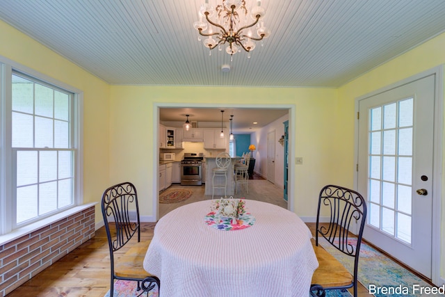 7561 Wiczer Dr, Whitehall, MI 49461 - dining space with plenty of natural light, a chandelier, wood ceiling, baseboards, and light wood-type flooring