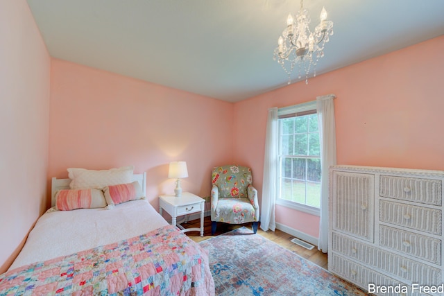 7561 Wiczer Dr, Whitehall, MI 49461 - bedroom featuring a chandelier, wood finished floors, and baseboards