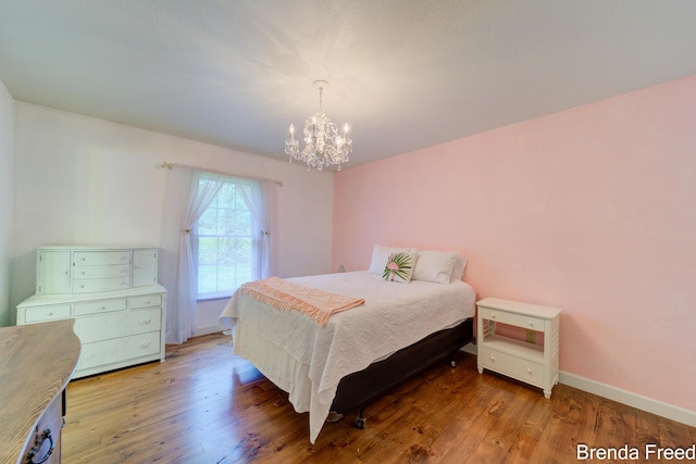 7561 Wiczer Dr, Whitehall, MI 49461 - bedroom featuring a chandelier, wood finished floors, and baseboards