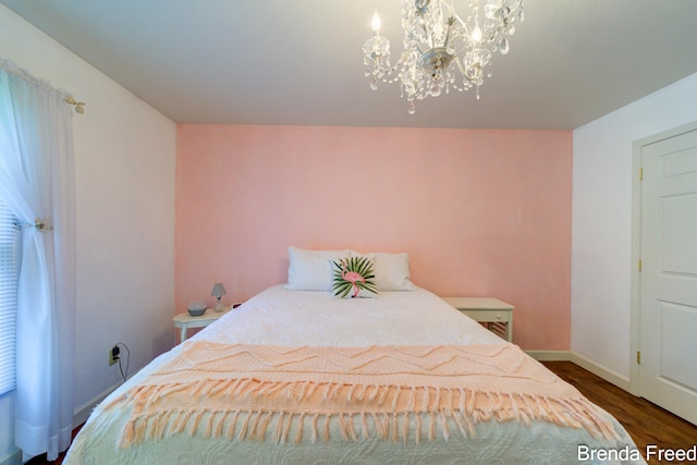 7561 Wiczer Dr, Whitehall, MI 49461 - bedroom with a chandelier, wood finished floors, and baseboards