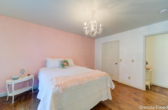 7561 Wiczer Dr, Whitehall, MI 49461 - bedroom with wood finished floors, a chandelier, and baseboards