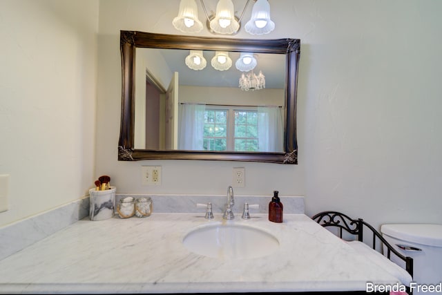 7561 Wiczer Dr, Whitehall, MI 49461 - bathroom featuring vanity, a chandelier, and toilet