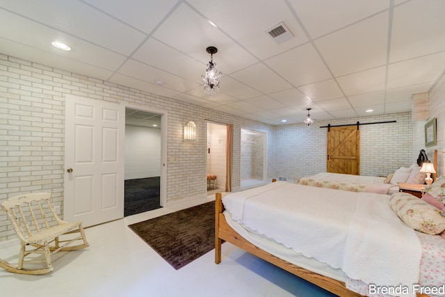 7561 Wiczer Dr, Whitehall, MI 49461 - bedroom with a barn door, a paneled ceiling, brick wall, concrete flooring, and recessed lighting