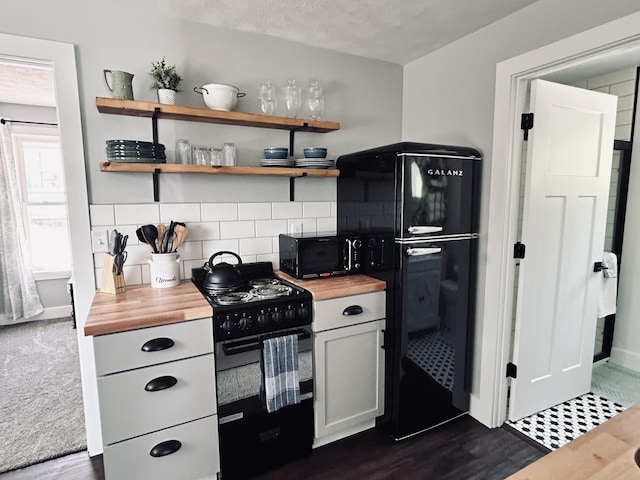 855 W Locust St, White Cloud, MI 49349 - kitchen with black appliances, wood counters, decorative backsplash, and dark wood-type flooring