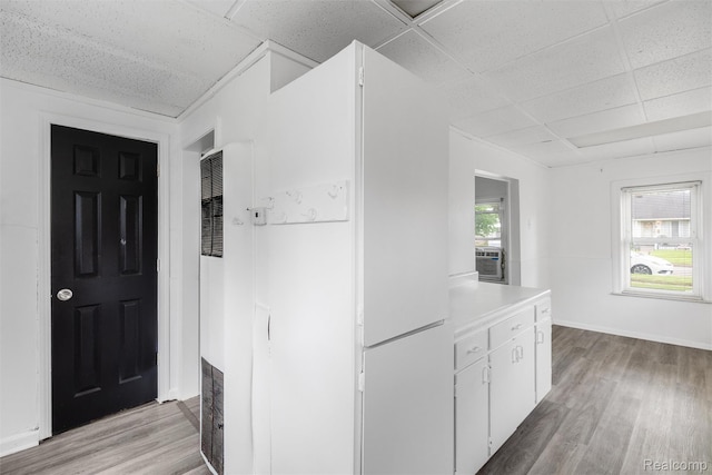 20515 Hollywood St, Harper Woods, MI 48225 - kitchen with a paneled ceiling, a heating unit, light wood-style floors, white cabinets, and light countertops