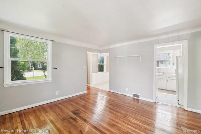 6008 Andersonville Rd, Waterford, MI 48329 - unfurnished room featuring wood finished floors, a sink, and baseboards
