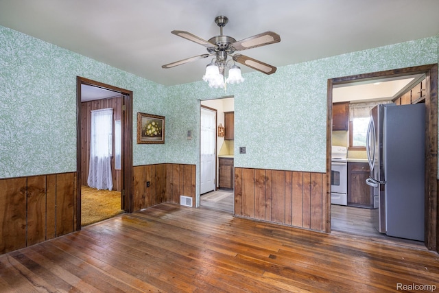 2500 Howe St, Shelby, MI 48317 - empty room with wainscoting, wood-type flooring, ceiling fan, wallpapered walls, and wood walls