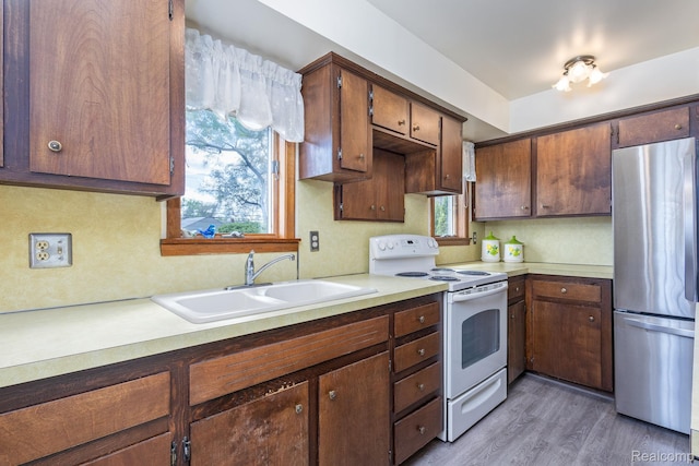 2500 Howe St, Shelby, MI 48317 - kitchen featuring freestanding refrigerator, white range with electric cooktop, a sink, light countertops, and wood finished floors