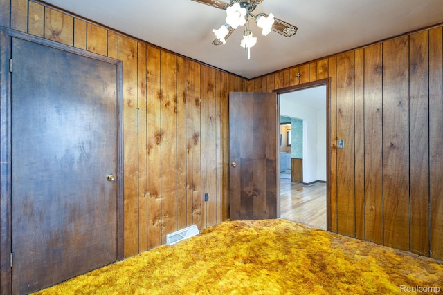 2500 Howe St, Shelby, MI 48317 - unfurnished bedroom with wooden walls, wood finished floors, and a ceiling fan