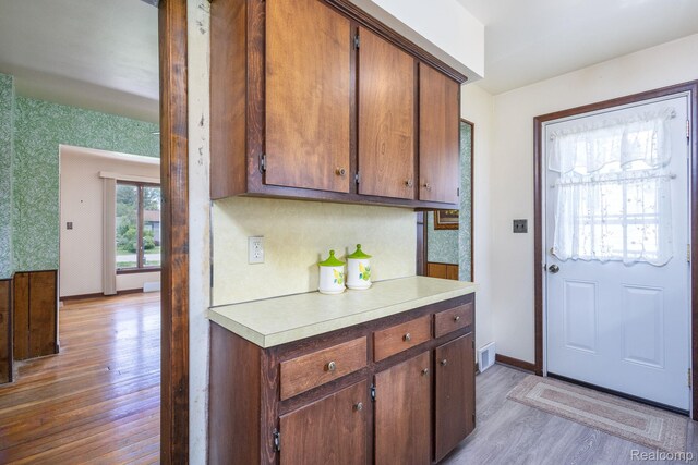 2500 Howe St, Shelby, MI 48317 - kitchen with light wood-style flooring, light countertops, baseboards, and wallpapered walls
